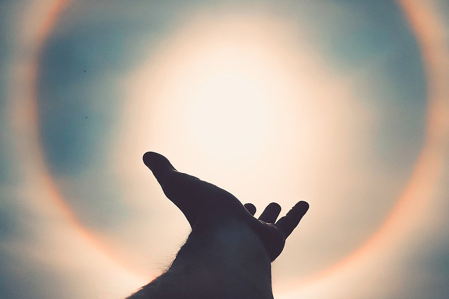 Ręka wyciągnięta w stronę Słońca